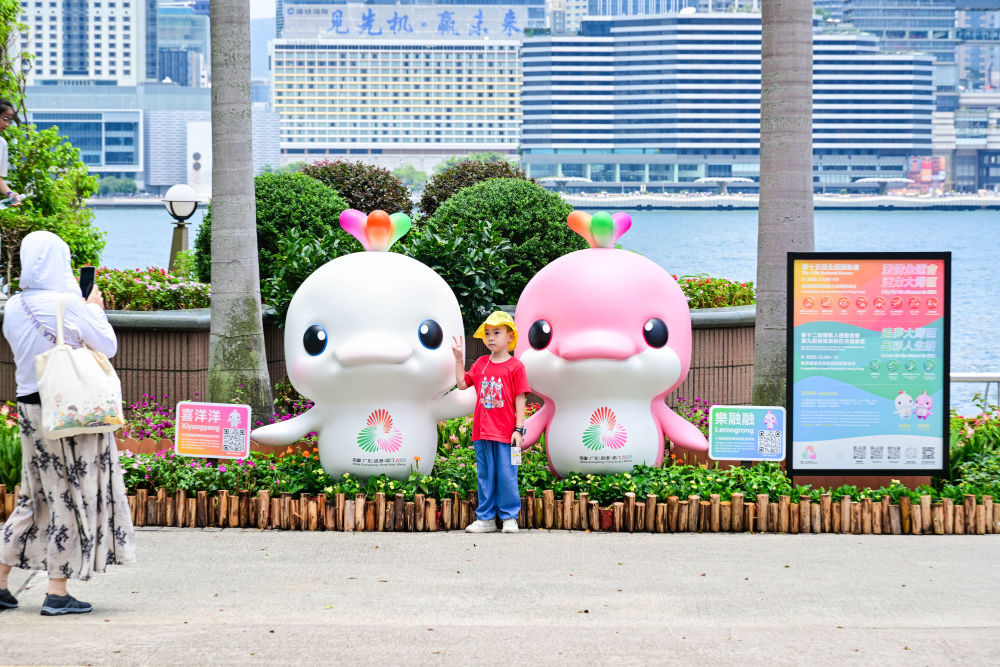香港金紫荆广场上，“喜洋洋”和“乐融融”‌笑意盈盈，与前来留影的孩童定格下美好瞬间。新华社记者 朱炜 摄