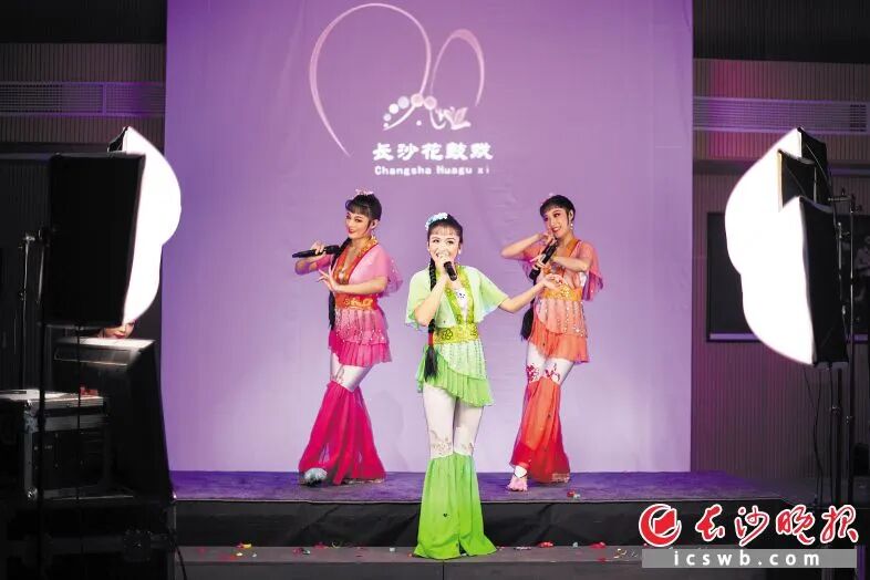 三位年轻演员在主播台上表演串烧花鼓戏选段。
